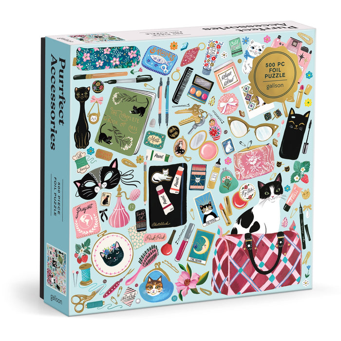The Purrfect Accessories 500 Piece Foil Puzzle by Christine De Carvalho features colorful, whimsical illustrations of cat-themed accessories like sunglasses, cosmetics, notebooks, and playful cats.