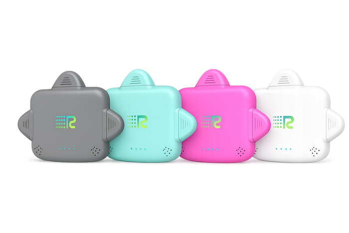 Four small electronic trackers in different colors (gray, mint green, pink, and white) lined up in a row against a plain white background.