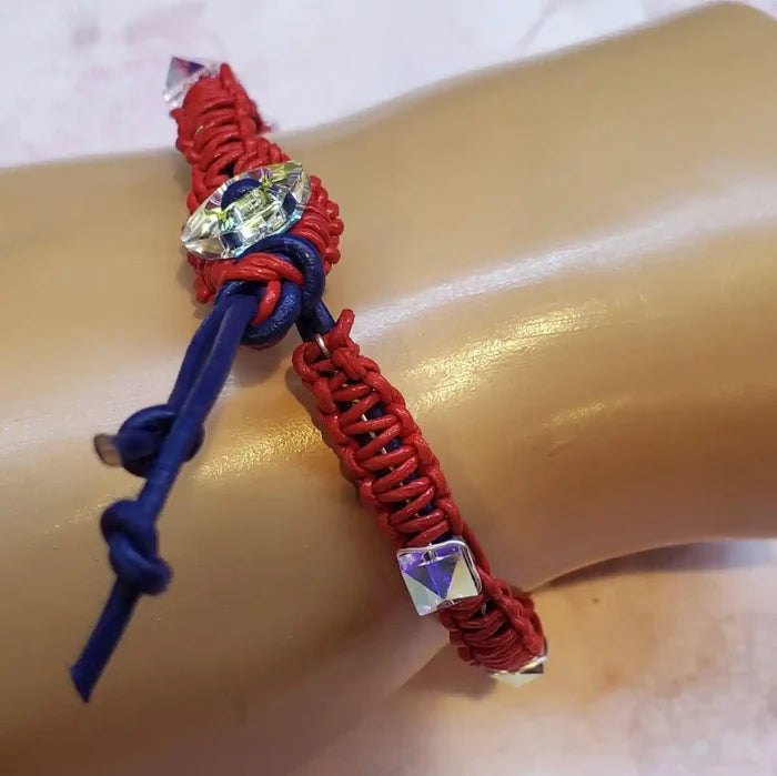 Red White and Blue Macrame Wire Wrap Crystal Spike Bracelet on a wrist, featuring red cord and Swarovski crystal spikes.