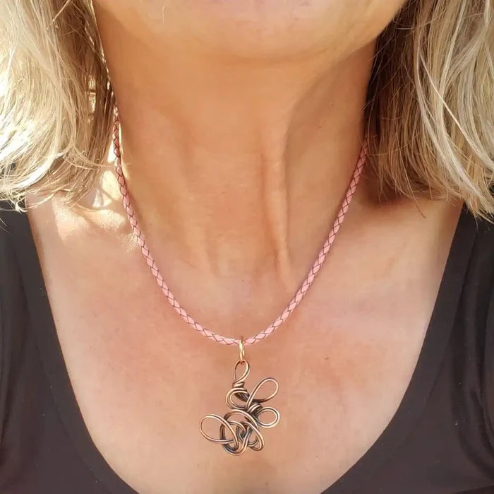 Reversible Interchangeable Copper Wire Sculpted Necklaces worn on a braided pink cord by a model.