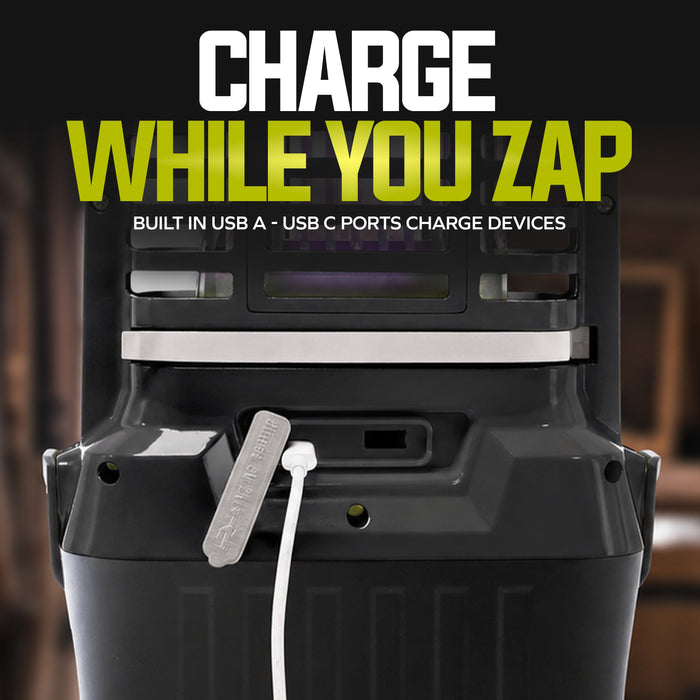 A close-up of a black portable power station with a white charging cable plugged in, under bold text reading 'CHARGE WHILE YOU ZAP' and smaller text 'BUILT IN USB A - USB C PORTS CHARGE DEVICES'.