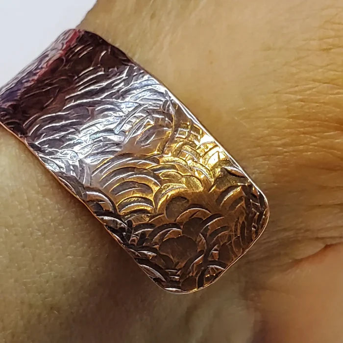 copper bar with embossed design on a wooden surface