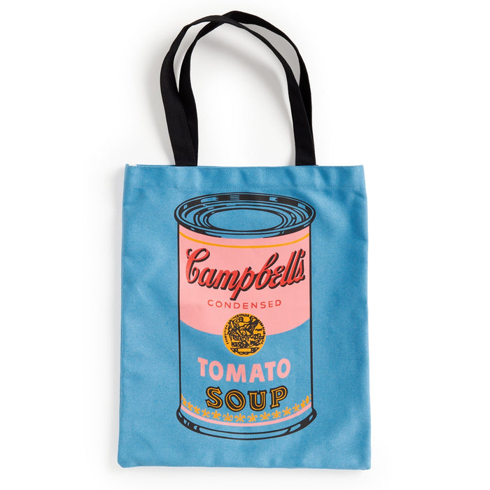 The Warhol Soup Can Volume 3 Canvas Tote Bag by Andy Warhol Foundation For The Visual Arts is a blue tote with black handles, featuring a pop art Campbell’s tomato soup can in pink, blue, yellow, and black.