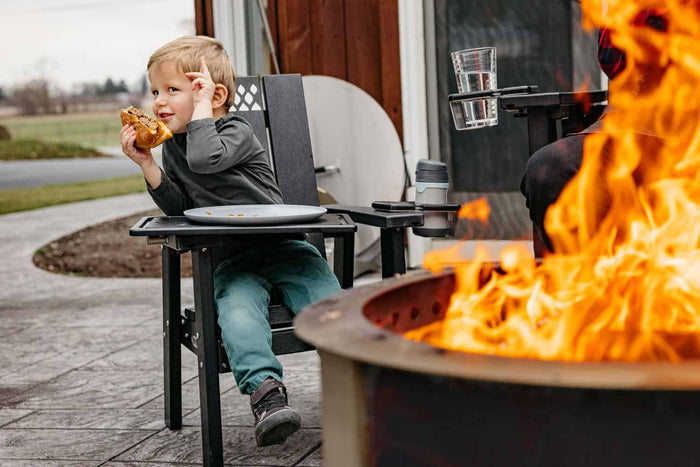 This is an image of a child eating a burger while sitting on an X Series kids chair