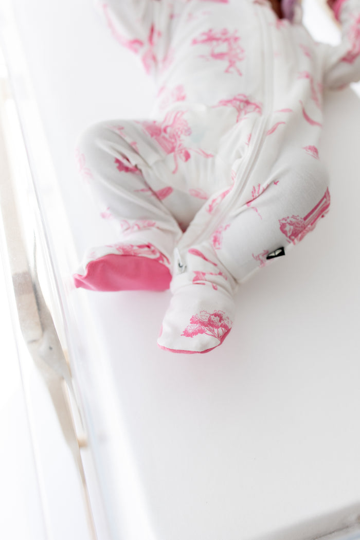 Footie with pink ballet toile pattern on a white background