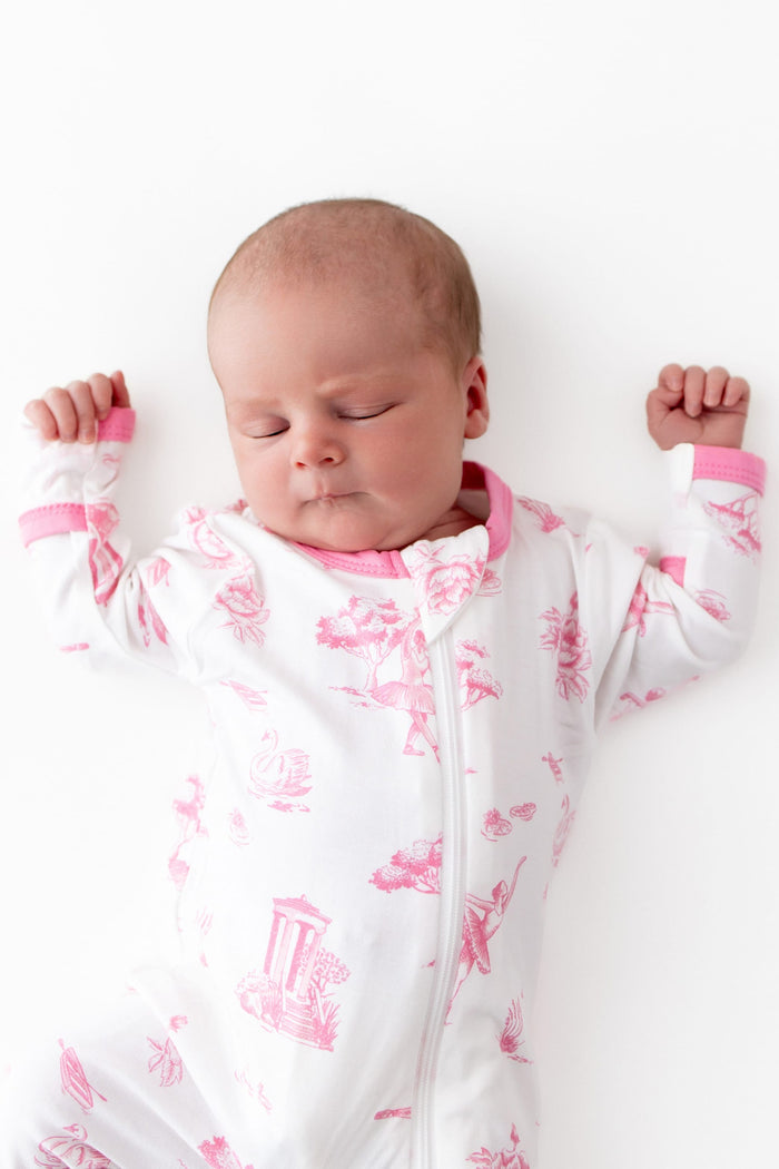 Close up of newborn baby wearing the Zippered Footie in Toile Ballet